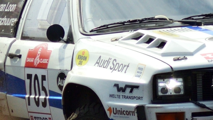 Eric v Loon-2×2 Rally car 705 Eric van Loon coming around the curve large cloud of dust kicked up behind him grid tile 5